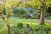 Garden with trees, gazebo and tulips 