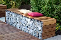 Gabion as a seating area in front of a bamboo hedge 