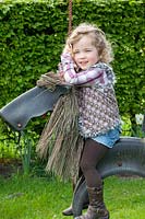 Child in the garden on a toy horse 