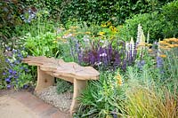 Seating area with perennials, Salvia nemorosa, Achillea Terracotta, Lupinus, Geranium, Anemanthele lessoniana 