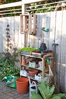 Work table in the garden in front of a wooden privacy screen 