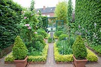 Small cottage garden with creeping spindle as bed edging, Euonymus fortunei 