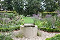 Bed with perennials and annuals and fountain in the middle, Verbena bonariensis; Nicotiana langsdorfii 