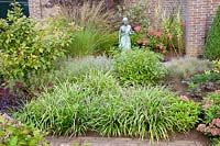 Autumn garden with grape lily (front), Liriope muscari 