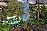 Seating area in the garden with daffodils, Narcissus triandrus Thalia 