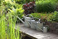 Watering cans at the pond edge 