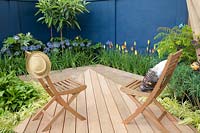 Small terrace with wooden deck, ornamental lily, torch lily, Agapanthus Lilac Lullaby, Kniphofia 