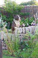 Natural stone wall and dog made of willow 