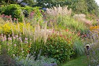 Bed with easy-care perennials, Calamagrostis brachytricha; Miscanthus; Rudbeckia fulgida Goldsturm; Persicaria amplexicaulis, Solidago Fireworks, Physostegia virginiana 