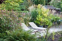 Deck chairs between grasses and love-pearl bush, Callicarpa bodinieri, Miscanthus sinensis 