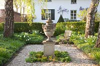 Formal garden area with vase in the middle 