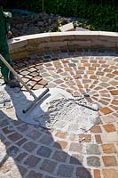 Freshly applied grout in a paving circle 