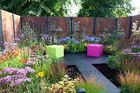 Modern garden with pond and laser-cut privacy screen, Campanula Prichards Variety, Imperata cylindrica Red Baron, Verbena bonariensis, Achillea Pretty Belinda, Helenium Moerheim Beauty, Achillea Terracotta, Agapanthus Blue Triumphator 