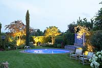 Illuminated garden with pool, crabapple and serviceberry, Malus, Amelanchier 
