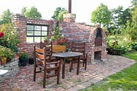 Seating area on wall with wood-fired oven 