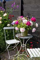 Seating on the terrace with bouquet of peonies, Paeonia 