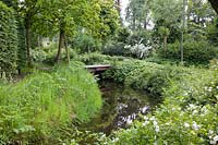 Canal with bridge and roses as riverbank planting 