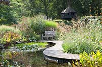 Pond with curved wooden walkway 