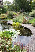 Pond with curved wooden walkway 