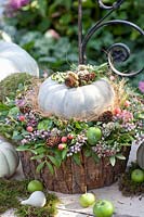 Autumnal arrangement with pumpkin, apples, flowers and leaves 