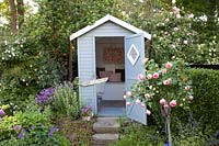 Garden with beach hut, Rosa Eden Rose; Rosa Mortimer Sackler, Rosa Blush Noisette 
