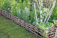 Bed edging made of woven willow branches 