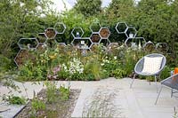 Garden with large insect hotel in the shape of honeycombs 