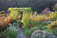 Kitchen garden with vegetables, herbs and scaffolding with gourds, Lageraria siceraria 