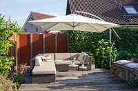 Modern garden with lounge furniture and hanging umbrella 