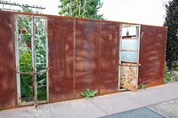 Corten steel privacy screen with a view of the garden 