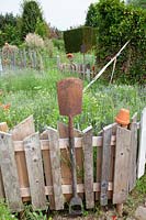 Fence made of old wooden boards and garden tools 