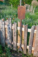Fence made of old wooden boards and garden tools 