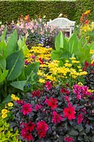 Seating area by the bed with annuals and dahlias 