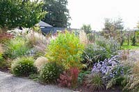 Bed with grasses and perennials in September 