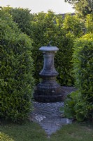 Sundial in stone paved hidden garden room