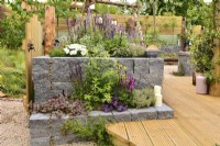 Raised bed, made of Connemara decorative wall system, near wooden decking. Planted with Thymus vulgaris,  Astilbe, Gillenia trifoliata, Leucanthemum superbum, Salvia Nemorosa, Thymus vulgaris, June
Designer: Mary Anne Farenden. Bord Bia Bloom, Super Garden, Dublin, Ireland.  


