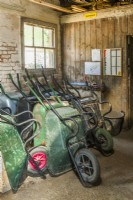 Collection of wheelbarrows parked in a potting shed.