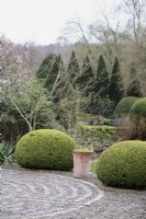 Pavement maze surrounded by evergreens including clipped yew at York Gate Garden in February