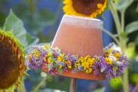 Upturned flower pot with a wreath of summer flowers including Allium, Agastache and Tanacetum vulgare.