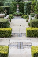 Path of paving slabs and brick leading to the Shakespeare Monument with low hedges of clipped Yew. April. Spring.