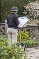 Artist in Residence Clair Hodgson sketching in the Yew Garden. April. Spring. 