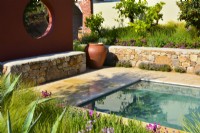 Mediterranean garden with orange wall compartmentwith a circle window, pool and stone raised bed. June
Designer - Alan Rudden