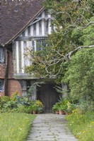 View along a stone path to the front door of a country house in early Summer - May